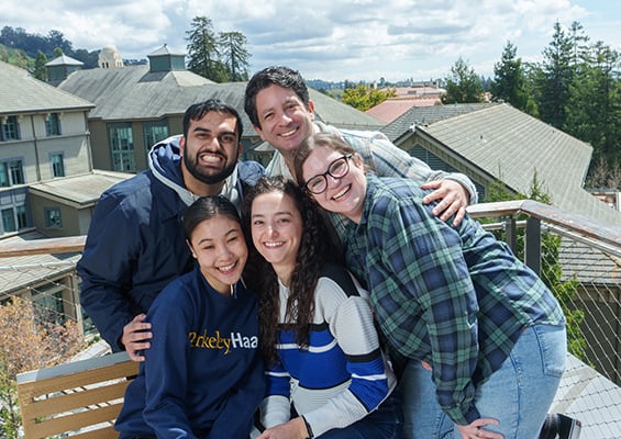 Students smile and pose atop of Chou Hall's Spieker Forum rooftop