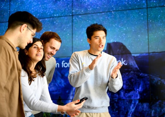 MBA Students and presenters in front of blue screen. 